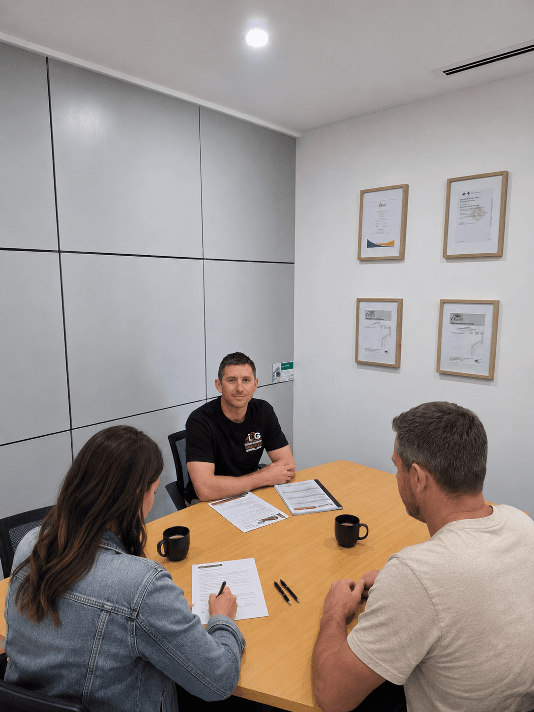 Clients signing documents with the builder before construction